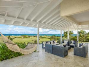 a porch with a hammock and a view of the ocean at Larimar - Luxury Ocean Front Villa in Saint Philip