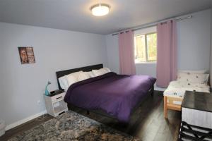 um quarto com uma cama roxa e uma janela em PA Sea View Deck House em Port Angeles
