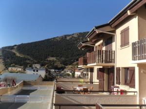 une vue sur un bâtiment avec une montagne en arrière-plan dans l'établissement Appart T2 cabine grande terrasse classé 2 *, aux Angles