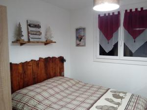 - une chambre avec un lit doté d'une tête de lit en bois dans l'établissement Appart T2 cabine grande terrasse classé 2 *, aux Angles