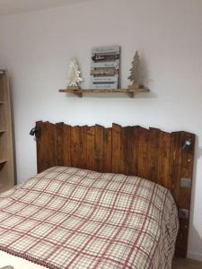 a bedroom with a bed with a wooden headboard and shelves at Appart T2 cabine grande terrasse classé 2 * in Les Angles