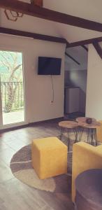 a living room with a television and a yellow stool at Vila Lena in Međuvršje +61 photos