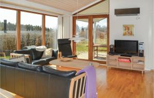 a living room with black leather furniture and a tv at Awesome Home In Rnde With 3 Bedrooms And Wifi in Rønde