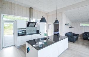 GlesborgにあるBeautiful Home In Glesborg With Kitchenのキッチン(白いキャビネット、黒いカウンタートップ付)