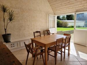 uma sala de jantar com uma mesa de madeira e cadeiras em Maison au calme à 2 pas du port em Cancale