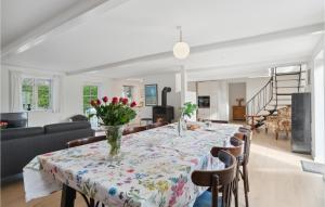 a dining room table with a vase of flowers on it at 4 Bedroom Stunning Home In Sams in Brundby