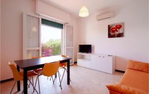 un soggiorno con tavolo, sedie e TV di 1 Bedroom Stunning Apartment In Pietra Ligure a Pietra Ligure