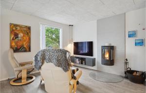 ein Wohnzimmer mit einem Stuhl und einem TV in der Unterkunft 4 Bedroom Cozy Home In Skjern in Skjern