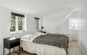 a white bedroom with a bed and two windows at 4 Bedroom Stunning Home In Sams in Brundby
