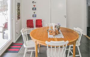 een eetkamer met een houten tafel en witte stoelen bij Cozy Home In Steninge With Wifi in Steninge