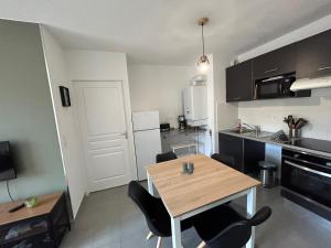 uma cozinha com mesa e cadeiras num quarto em Appartement meublé T3 Béziers em Béziers