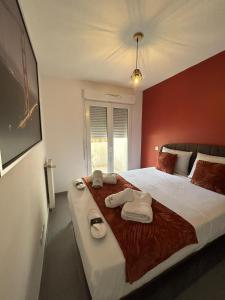um quarto com uma cama grande e toalhas em Appartement meublé T3 Béziers em Béziers