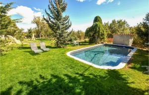 a swimming pool in a yard with two chairs at Amazing Home In Sault With Outdoor Swimming Pool in Sault-de-Vaucluse