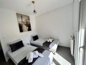 Habitación pequeña con 2 camas y sofá en Appartement meublé T3 Béziers, en Béziers