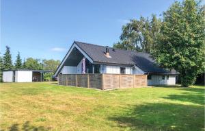 a house with a wooden fence in a yard at Awesome Home In Glesborg With 3 Bedrooms And Wifi in Bønnerup