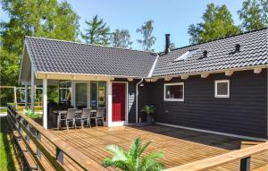 FjellerupにあるAmazing Home In Glesborg With Saunaの木製デッキ付黒家