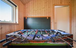 a game room with a table with baseball bats at Four-Bedroom Holiday Home Glesborg With A Room Hot Tub 07 in Fjellerup