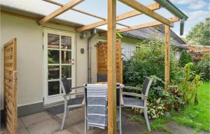 a patio with a table and chairs under a pergola at 2 Bedroom Pet Friendly Apartment In Ringkbing in Ringkøbing