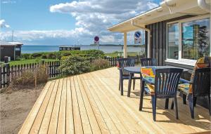a wooden deck with a table and chairs on a house at Beautiful Home In Rnde With 3 Bedrooms And Wifi in Rønde