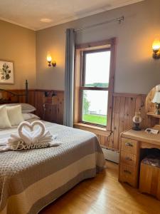 a bedroom with a bed and a window at Auberge l'Intermède du lac in Disraeli