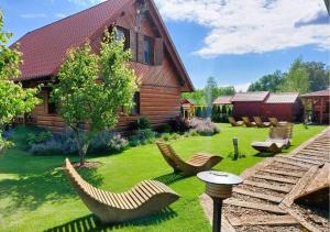 un patio con sillas y una casa de madera en Domki Lawendowy Zakątek en Boszkowo