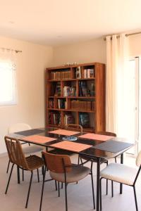 a dining room with a table and chairs and a book shelf at Villa plain pied vue terrasse in Port-Vendres
