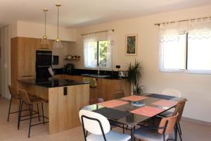 una cucina e una sala da pranzo con tavolo e sedie di Villa plain pied vue terrasse a Port-Vendres
