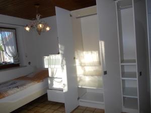 1 dormitorio con cama, armario y ventana en 140qm in 83052 between Munich+Rosenheim, en Bruckmühl