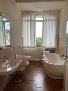 a bathroom with two sinks and a tub and two toilets at Winter Home G&D in Milano Marittima