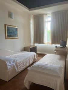 um quarto de hotel com duas camas e uma janela em Winter Home G&D em Milano Marittima
