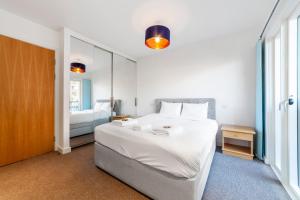 a bedroom with a large white bed and a window at Amazing 3BDR Duplex wbalcony East London in London