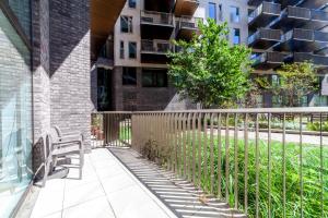 a bench on a sidewalk next to a building at Amazing 3BDR Duplex wbalcony East London in London