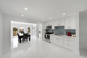a kitchen with white cabinets and a table in it at Dania Beach Unit 1 By Pmi in Dania Beach