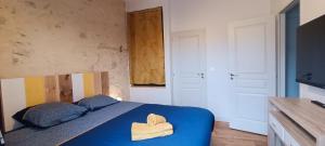 una camera con un letto blu e due asciugamani di CANTETEAU - Agreable maison chaleureuse et conviviale a Les Sables-dʼOlonne