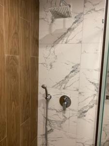 a bathroom with a shower with a marble wall at Cozy Riverside Pine Studio E5 in Borovets