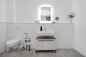 ein weißes Bad mit einem Waschbecken und einem WC in der Unterkunft Gemütliches Loftparadies - Küche - Parkplatz in Steinhagen