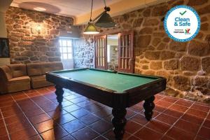 a pool table in a room with a stone wall at Beautiful 10-Bed Cottage in Celorico with Pool in Celorico da Beira