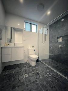 a bathroom with a toilet and a sink and a shower at Luxury New 5 Bedroom 3 Bathroom+ Study/ Back Yd in Schofields