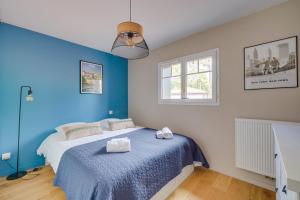 a blue bedroom with a bed and a window at Villa des OSMANTHES in La Teste-de-Buch