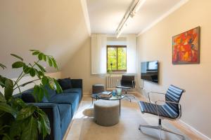sala de estar con sofá azul y sillas en Hotel Klostergasthof, en Thierhaupten