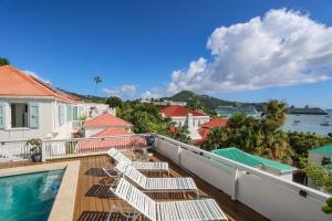 a balcony with chairs and a swimming pool at At Home in the Tropics in Charlotte Amalie