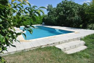 a swimming pool in a yard with stairs around it at Gîte Gers La Métairie in Cézan