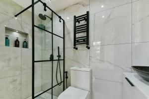 a white bathroom with a toilet and a sink at London 2-Bedrooms Apartment in London