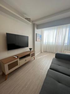 sala de estar con TV de pantalla plana grande en Luxuoso Apartamento na Ponta da Areia en São Luís