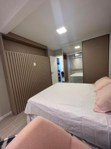 a bedroom with a large bed and a mirror at Luxuoso Apartamento na Ponta da Areia in São Luís