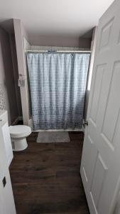 a bathroom with a shower and a toilet and a door at Private room and bathroom in Providence