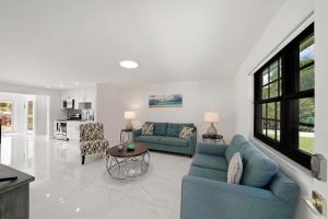 una sala de estar con 2 sofás azules y una mesa. en Dania Beach Unit 1 By Pmi en Dania Beach