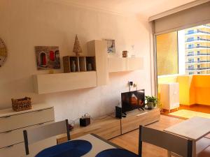 a living room with a tv and a table at Palmera del Mar in Puerto de la Cruz +9 photos
