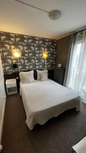 een slaapkamer met een groot bed en een stenen muur bij Hôtel Marie Louise in Enghien-les-Bains