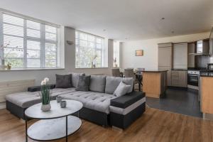 a living room with a couch and a kitchen at Central 2 Bed Pavilion Apartment in Brighton & Hove